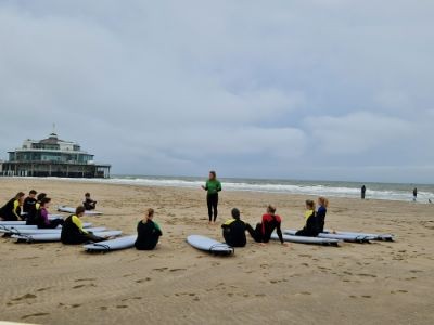 een groep op het strand klaar om te gaan surfen, duidelijk meerdere activiteiten op het strand